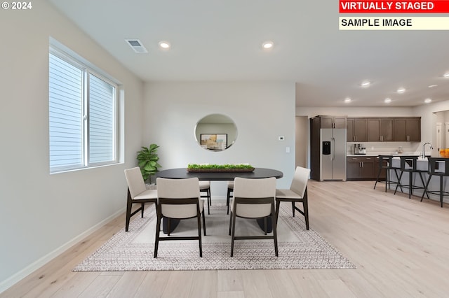 dining room with sink and light hardwood / wood-style flooring