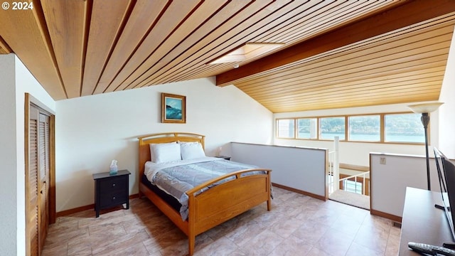 bedroom with vaulted ceiling with skylight, a closet, and wood ceiling