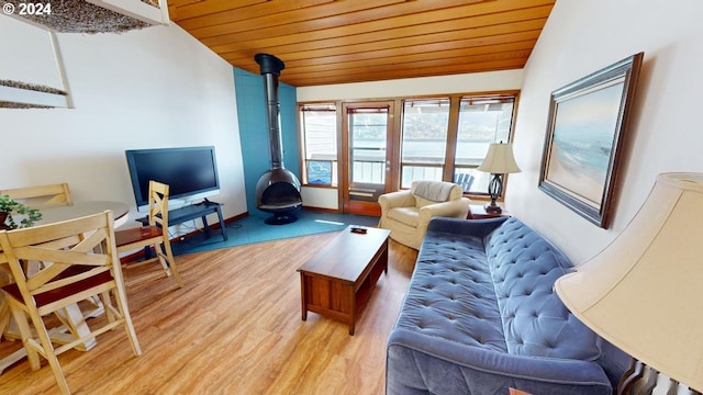 living room with wood ceiling, lofted ceiling, wood-type flooring, french doors, and a wood stove