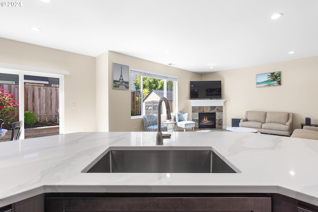 kitchen featuring light stone counters and sink