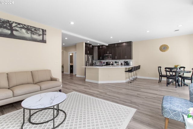 living room with light wood-type flooring and sink