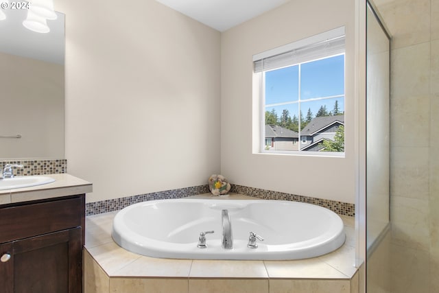 bathroom featuring vanity and tiled bath