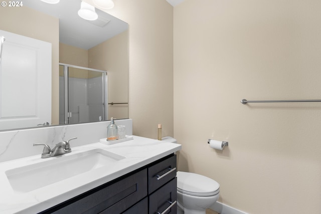 bathroom featuring toilet, an enclosed shower, and vanity