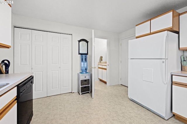 kitchen featuring white refrigerator, dishwasher, and white cabinets