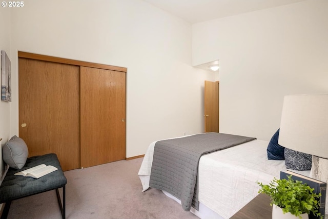 bedroom with light carpet, a closet, and a towering ceiling