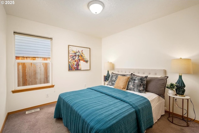 carpeted bedroom featuring visible vents, baseboards, and a textured ceiling