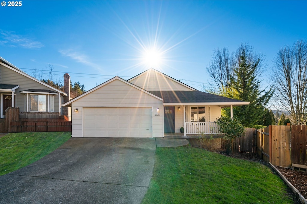 view of front of home featuring covered porch, a front lawn, and a garage