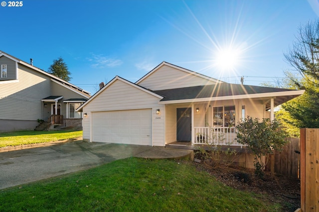 ranch-style house featuring a porch, a front yard, and a garage