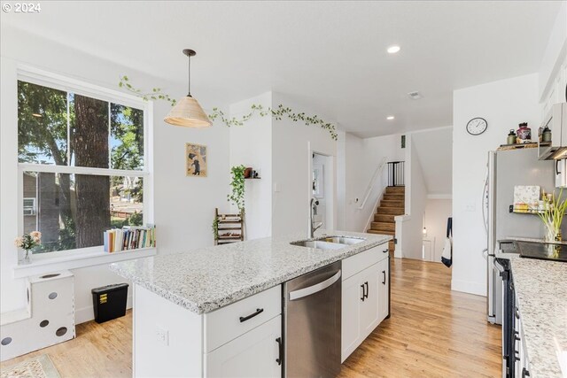 kitchen with light hardwood / wood-style flooring, sink, light stone counters, white cabinetry, and dishwasher