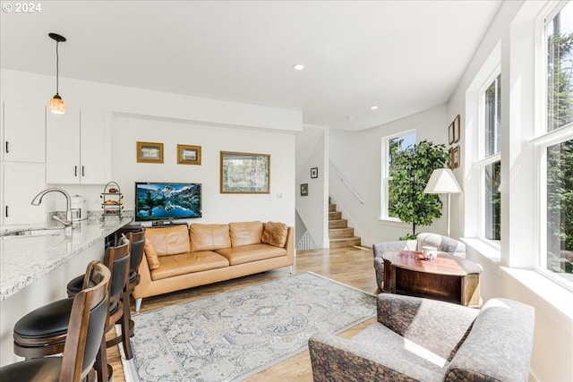 living room with light hardwood / wood-style floors and sink