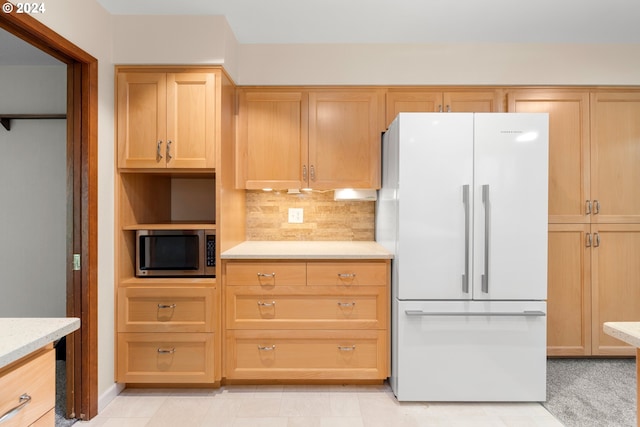 kitchen with decorative backsplash, light brown cabinets, white fridge, and light tile patterned flooring