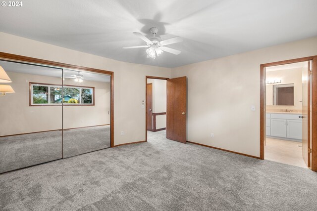 unfurnished bedroom featuring ceiling fan, light carpet, and a closet