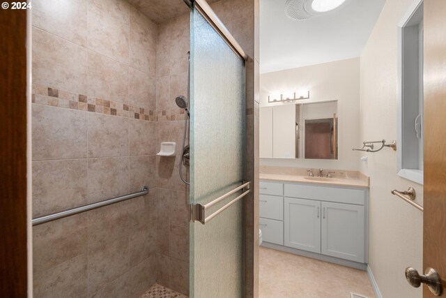 bathroom with a shower with door and vanity