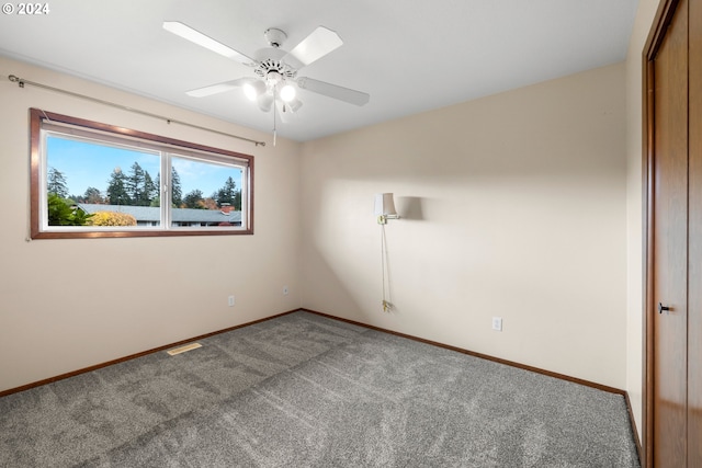 carpeted spare room with ceiling fan