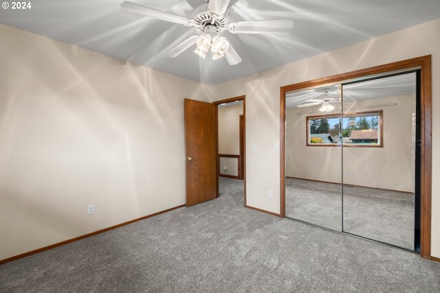 unfurnished bedroom featuring ceiling fan, a closet, and carpet