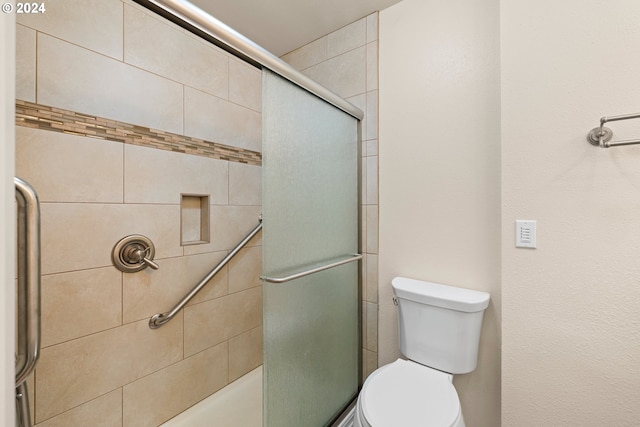 bathroom with toilet and a shower with shower door