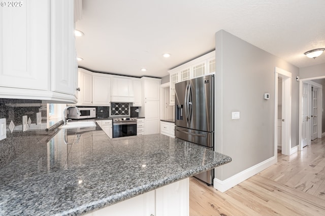 kitchen featuring light wood-style flooring, a sink, tasteful backsplash, wall oven, and stainless steel fridge with ice dispenser