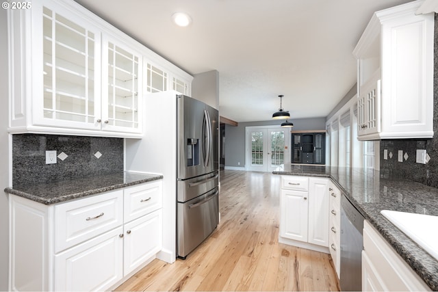 kitchen with glass insert cabinets, white cabinets, appliances with stainless steel finishes, and light wood-type flooring