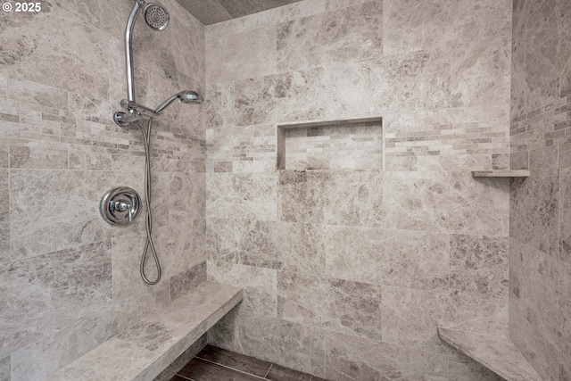 interior details featuring tiled shower