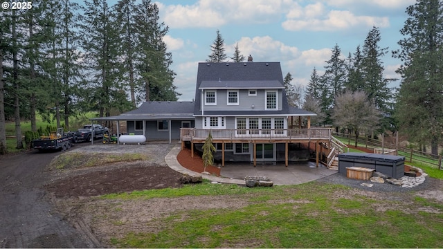 rear view of house with a patio, fence, driveway, a hot tub, and a deck