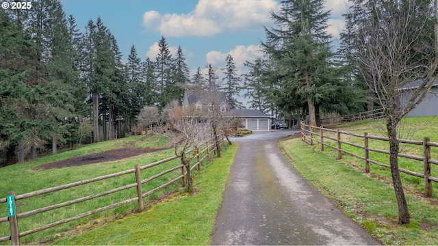 exterior space featuring a front lawn, fence, and driveway