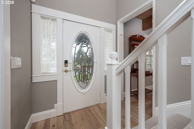 entryway featuring stairs, wood finished floors, and baseboards