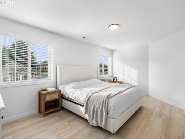 bedroom featuring multiple windows and light wood-type flooring