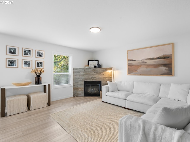 living room featuring light wood-type flooring and a fireplace