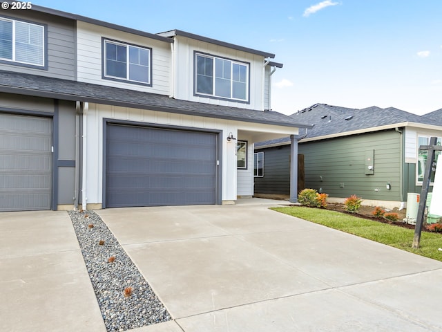 view of front facade featuring an attached garage, roof with shingles, board and batten siding, and concrete driveway