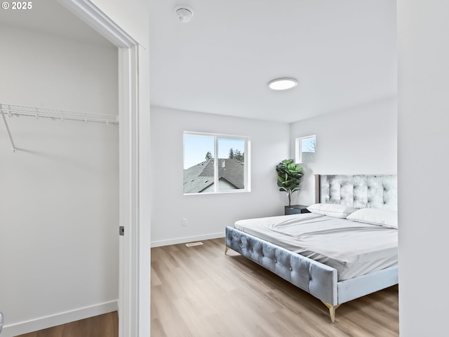 bedroom with baseboards and wood finished floors