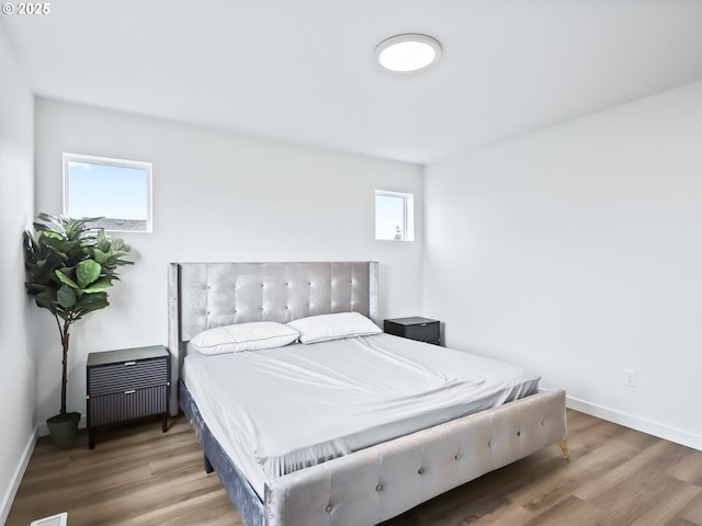 bedroom with baseboards and wood finished floors