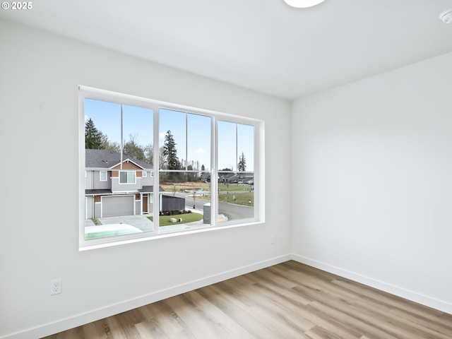 empty room with light wood-style floors and baseboards