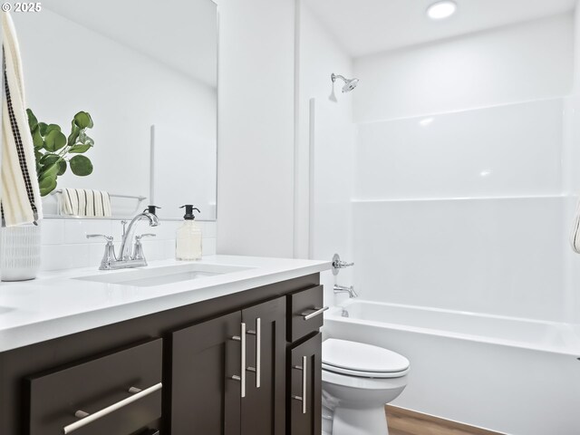 full bath featuring toilet, shower / bathtub combination, wood finished floors, and vanity