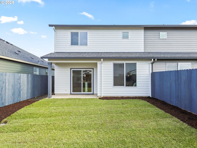 back of house featuring a lawn, a patio area, and a fenced backyard