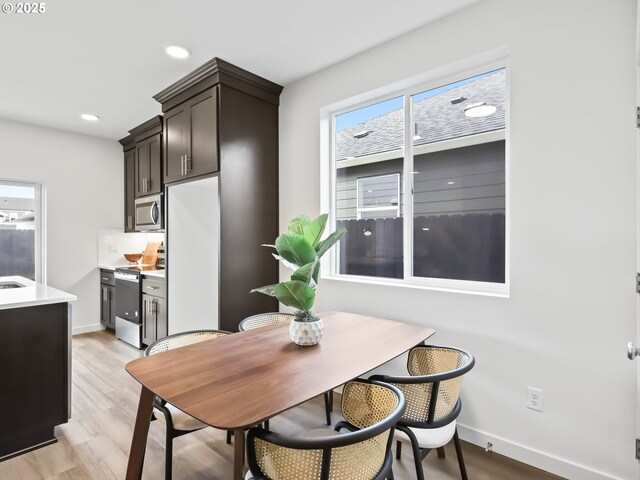 dining room featuring recessed lighting, light wood-type flooring, and baseboards