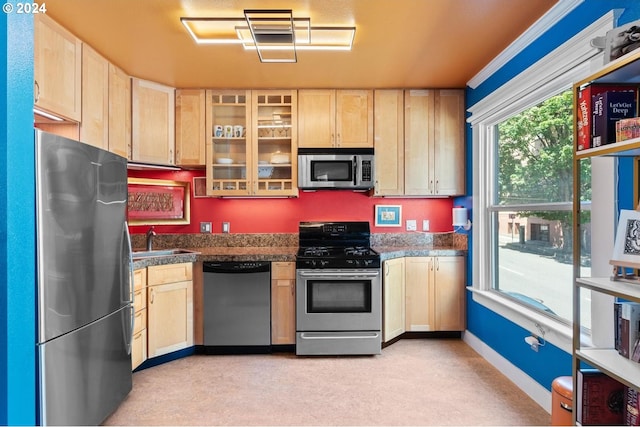 1104 SW Columbia St Unit 105, Portland, OR 97201 - kitchen featuring appliances with stainless steel finishes, light brown cabinetry, glass insert cabinets, and light colored carpet