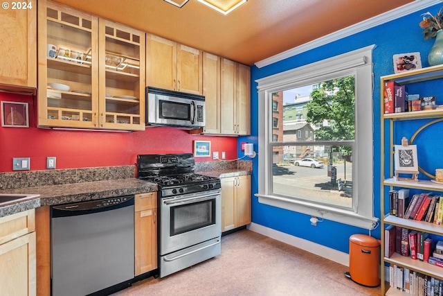 1104 SW Columbia St Unit 105, Portland, OR 97201 - kitchen with stainless steel appliances, light brown cabinets, ornamental molding, and tile countertops