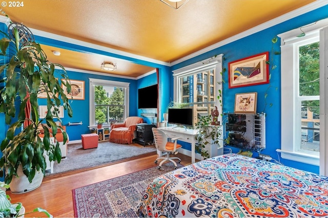 bedroom featuring hardwood / wood-style flooring and crown molding