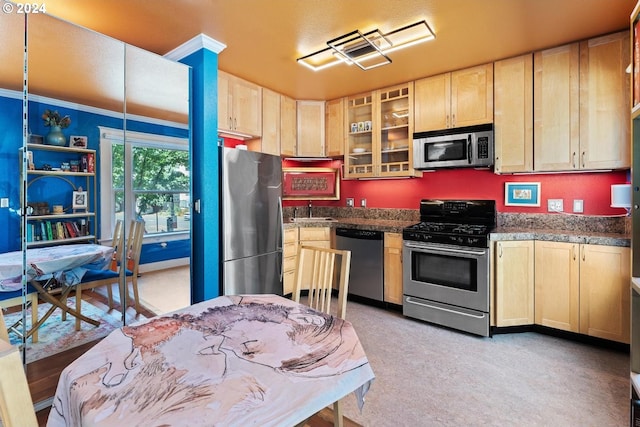 kitchen featuring appliances with stainless steel finishes, ornamental molding, light brown cabinetry, and sink