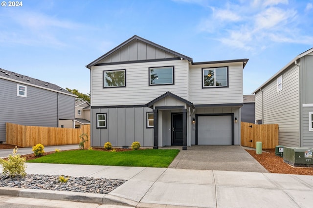 view of front facade with a garage, a front yard, and central AC unit