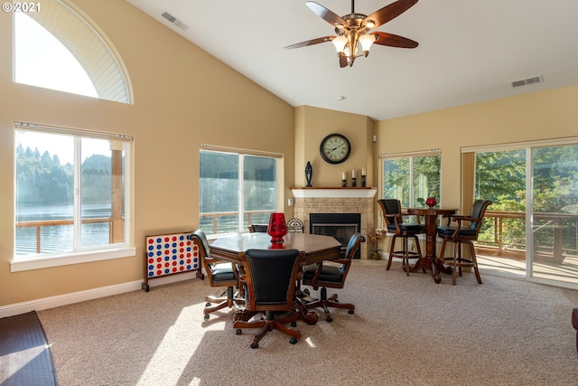 dining space with light carpet, plenty of natural light, and a tile fireplace