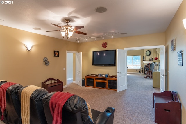 carpeted living room with ceiling fan and track lighting