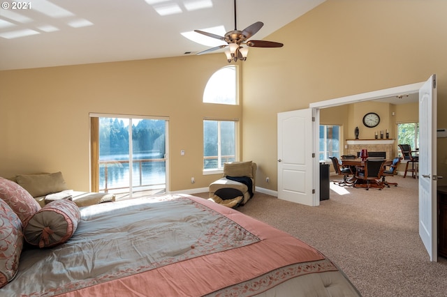 carpeted bedroom with ceiling fan and high vaulted ceiling