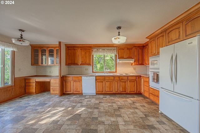 91235 N Bank Ln, Coquille, OR 97423 - kitchen featuring white appliances, light countertops, built in desk, under cabinet range hood, and brown cabinets