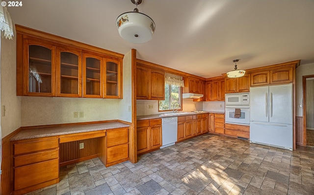 91235 N Bank Ln, Coquille, OR 97423 - kitchen with brown cabinets, under cabinet range hood, white appliances, glass insert cabinets, and built in study area