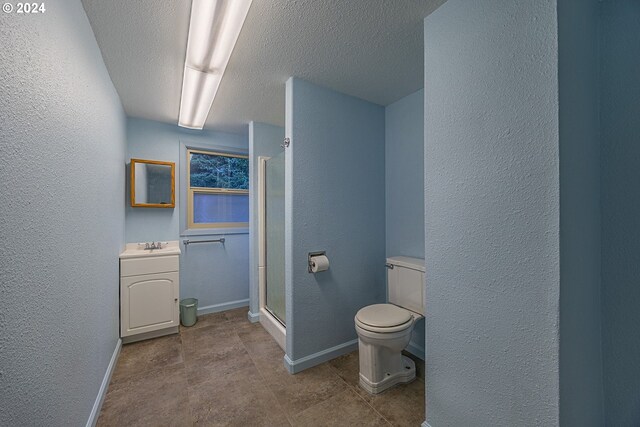 bathroom featuring vanity, an enclosed shower, a textured ceiling, tile patterned floors, and toilet