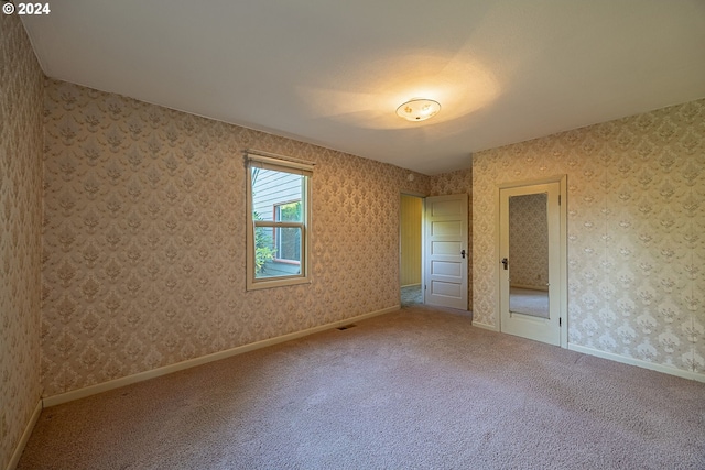 91235 N Bank Ln, Coquille, OR 97423 - unfurnished bedroom featuring visible vents, baseboards, carpet flooring, and wallpapered walls