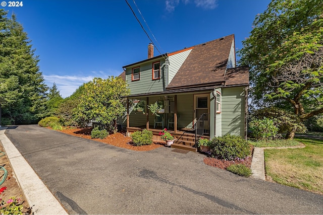 91235 N Bank Ln, Coquille, OR 97423 - view of front of home featuring a shingled roof, covered porch, and a chimney