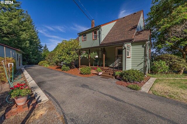91235 N Bank Ln, Coquille, OR 97423 - view of front of house with a shingled roof, covered porch, and a chimney
