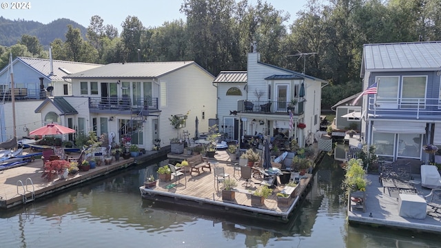 rear view of house with a balcony and a water view